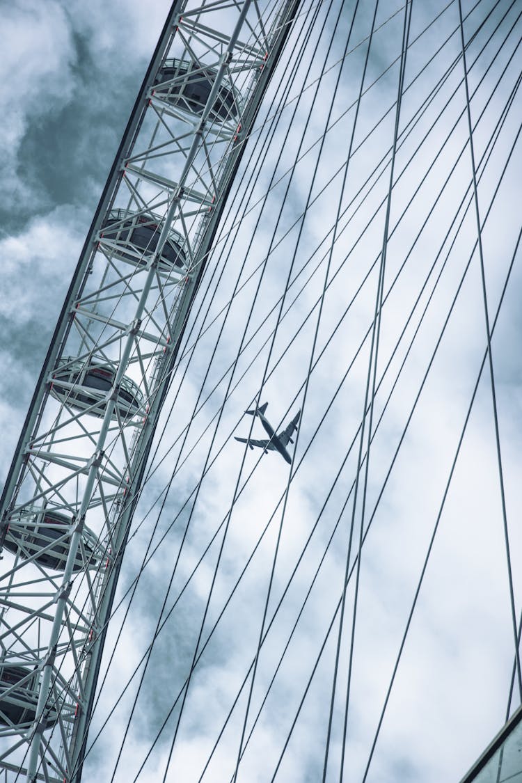 Airplane Seen Through Wires Of Ferris Wheel