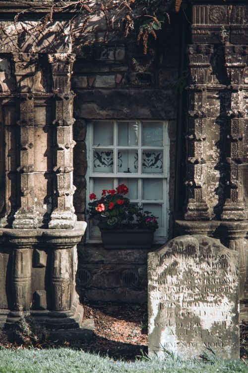 Free Intricate stone columns and an aged tombstone with flowers in a historic London setting. Stock Photo