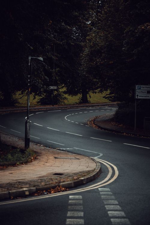 Free A serene winding road surrounded by lush greenery in London, capturing a tranquil outdoor scene. Stock Photo