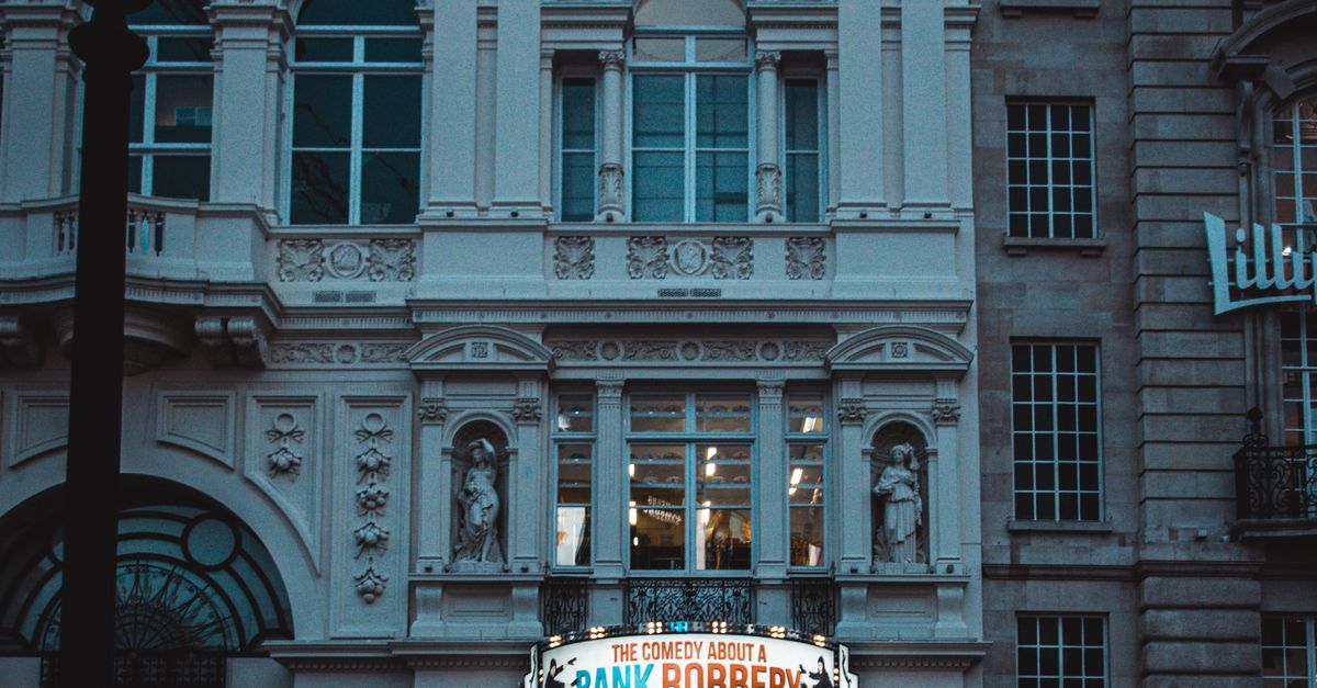Rüyada Banka Soygununa Tanık Olmak - Rüya Tabiri ve Anlamı - Crowded street in front of London's Criterion Theatre showcasing 'Bank Robbery' play at night.