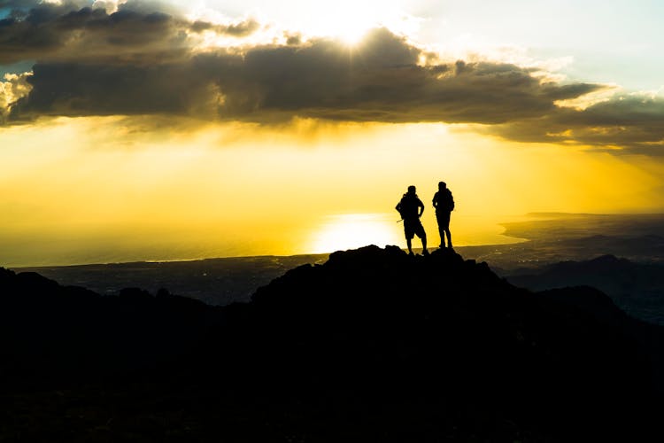 Silhouette Of Hikers On Mountain Top