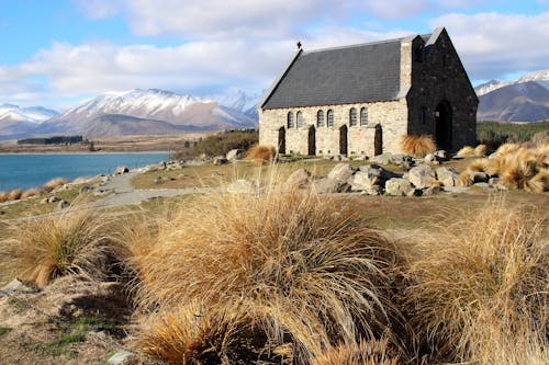 Photo of a Mountains Landscape with a Stone Church in the Foreground