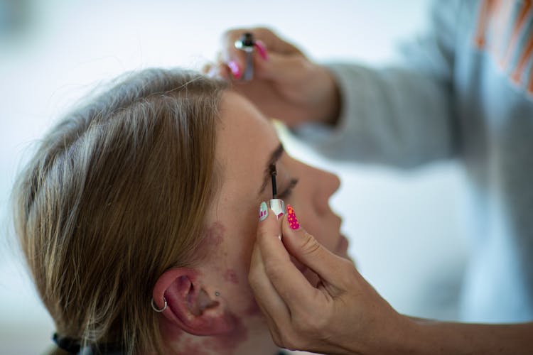 Person Applying Makeup On The Eyebrows Of A Woman