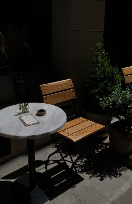 Free Charming café table setting in Beyoğlu, Istanbul with wooden chairs and greenery. Stock Photo