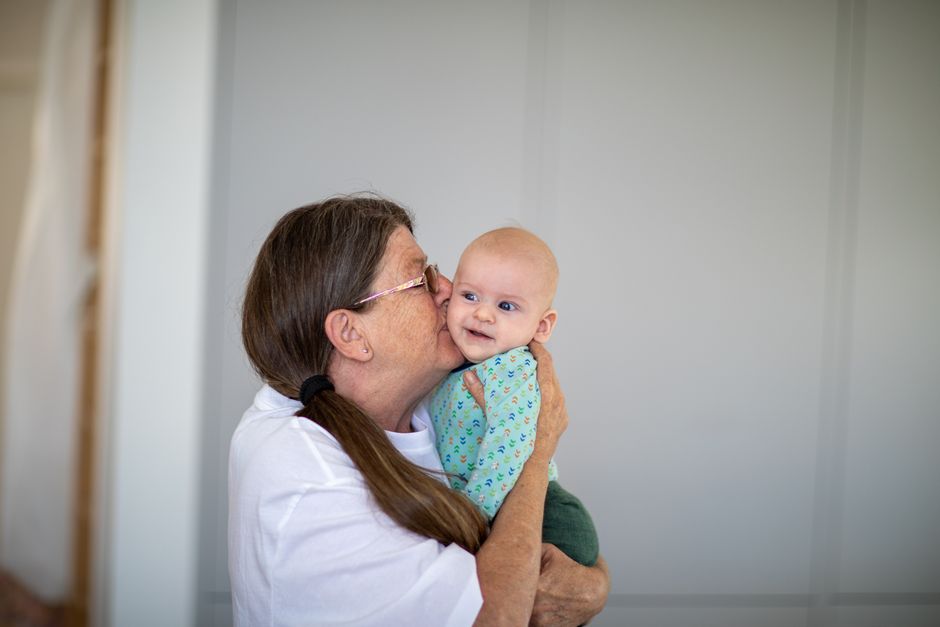 grandmother caring for baby grandchild indoors