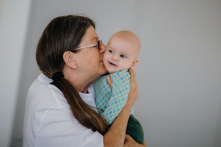 Grandmother Holding And Kissing A Baby