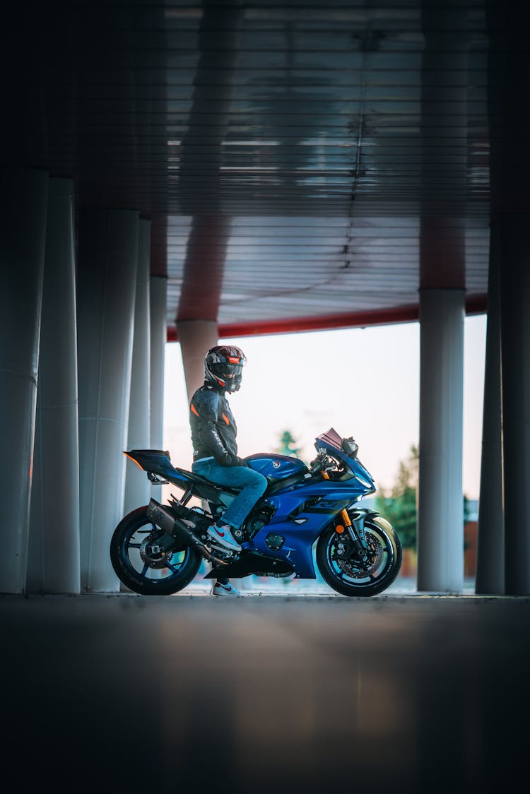 Person On A Blue Motorcycle Near Pillars