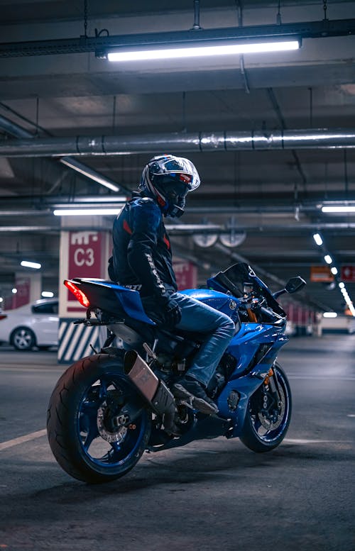 Free Person Wearing a Motorcycle Helmet on a Blue Sports Bike Stock Photo
