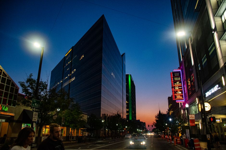 A modern city street at dusk with vibrant lights and urban buildings, capturing the essence of downtown nightlife.