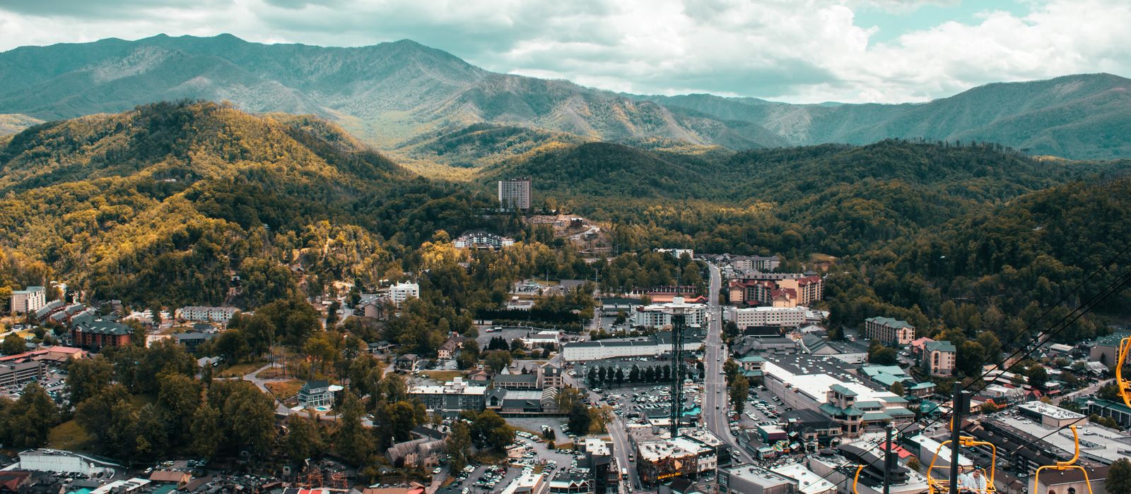Explore the vibrant cityscape of Pigeon Forge with mountain backdrop from a captivating aerial view.