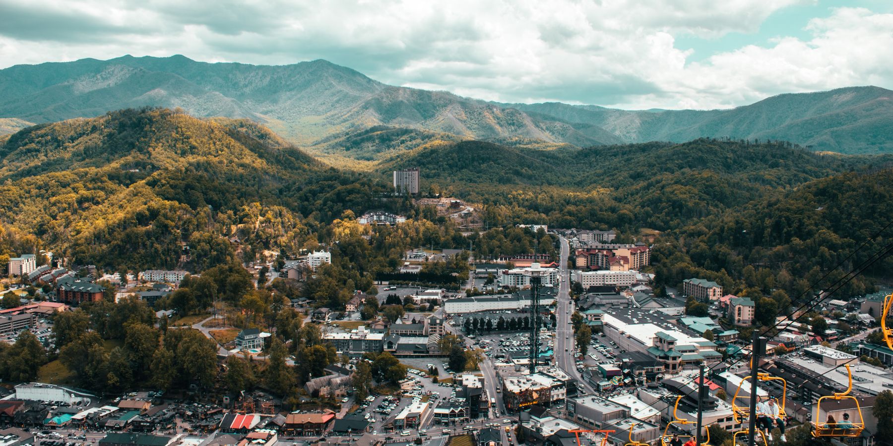 Explore the vibrant cityscape of Pigeon Forge with mountain backdrop from a captivating aerial view.