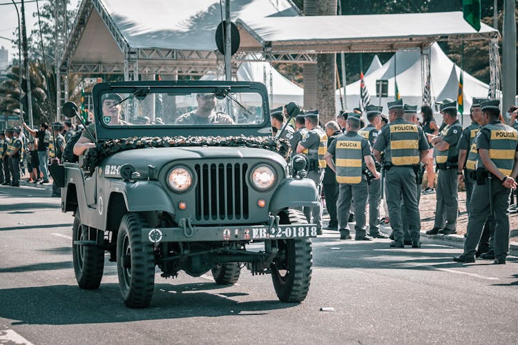 Army Men Riding On Military Jeep Wrangler On Street Parade