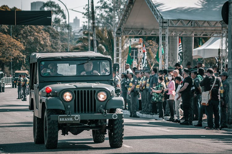 Army Men Riding On Military Jeep Wrangler On Street Parade