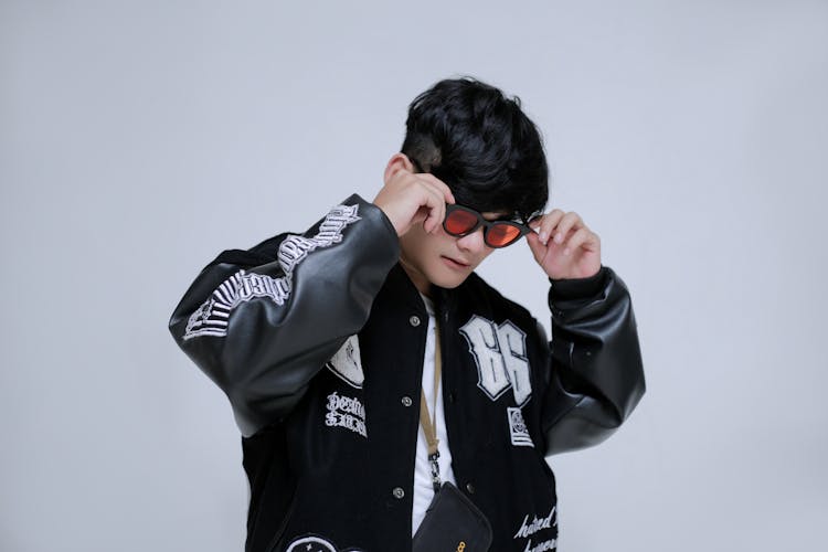 Man In Black And White Varsity Jacket In Black Background