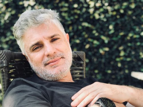 Free Close portrait of a relaxed adult man with gray hair reclining outdoors. Stock Photo