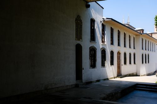 Free Quiet monastery courtyard with sunlight casting shadows on the white walls. Stock Photo