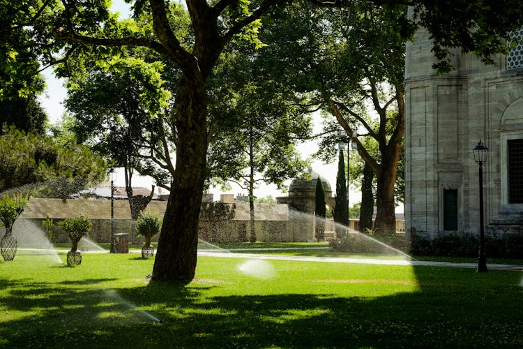 Water Sprinklers On Grass Field Outside A Building