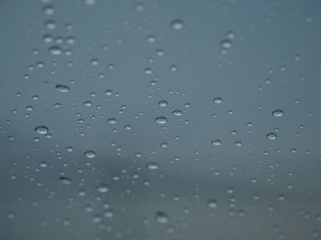 Close-up view of rain droplets on glass, creating a peaceful and serene scene.