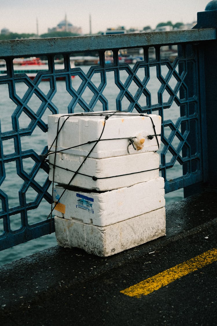 Styrofoam Container Near A Metal Fence