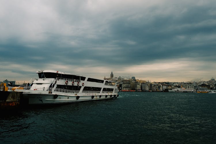 Ferry On A River And City Waterfront In Background