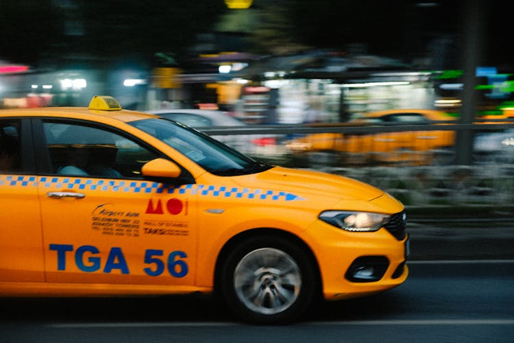 Yellow Taxi On City Street In Motion