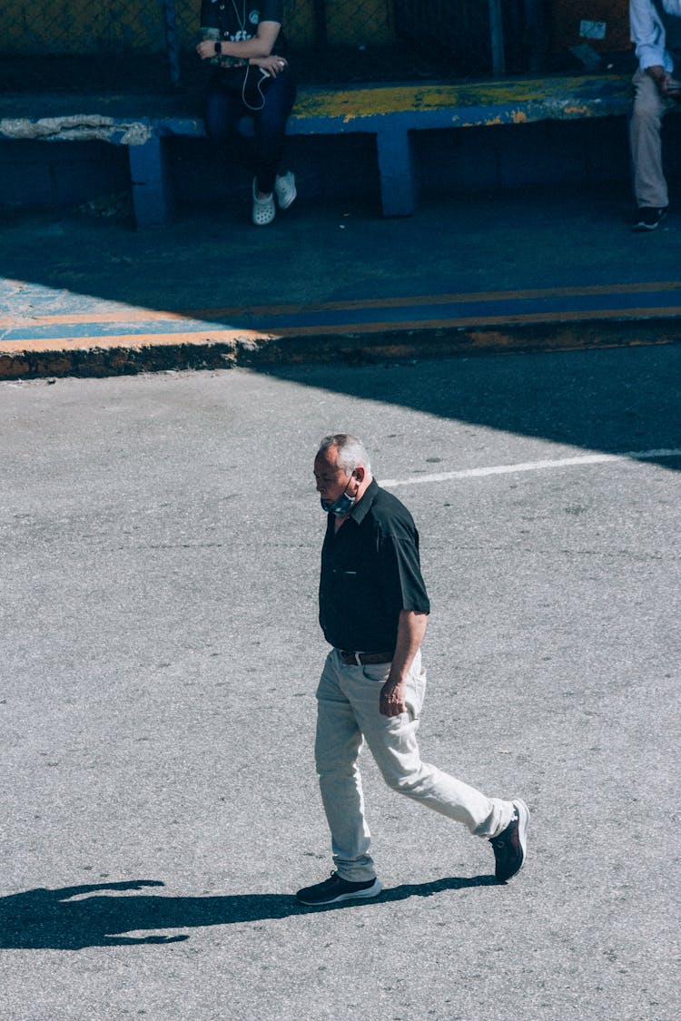 Man Walking Across Street Casting Shadow