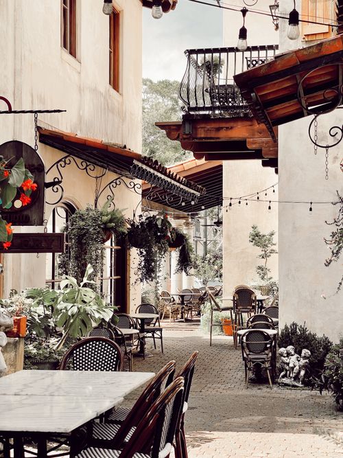 Free Beautiful al fresco dining spot with hanging plants and vintage decor in a narrow alley setting. Stock Photo