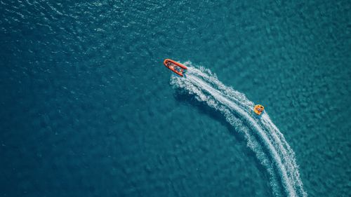 Free A speedboat creates waves in the pristine blue waters of Alaçatı, İzmir, Türkiye. Stock Photo