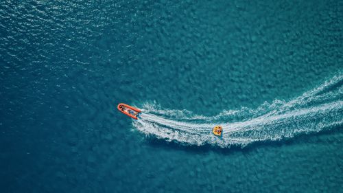 Free Aerial shot of a speedboat creating waves on clear blue waters in Alaçatı, Türkiye. Stock Photo