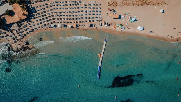 Stunning aerial view of Alaçatı Beach in İzmir, Türkiye with clear waters and sandy shore.