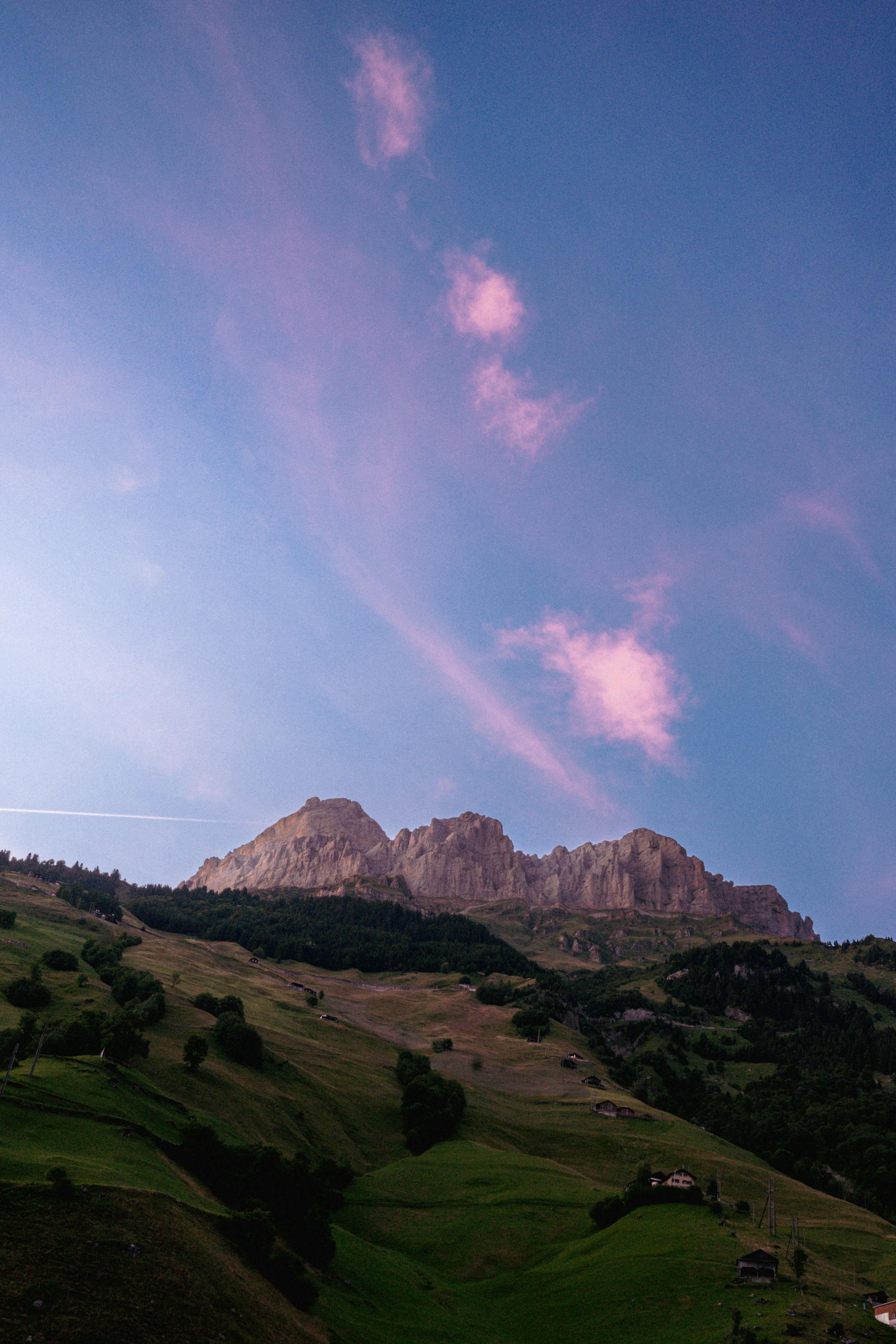 Beautiful mountain view at sunset with scenic pink clouds over the peaks.