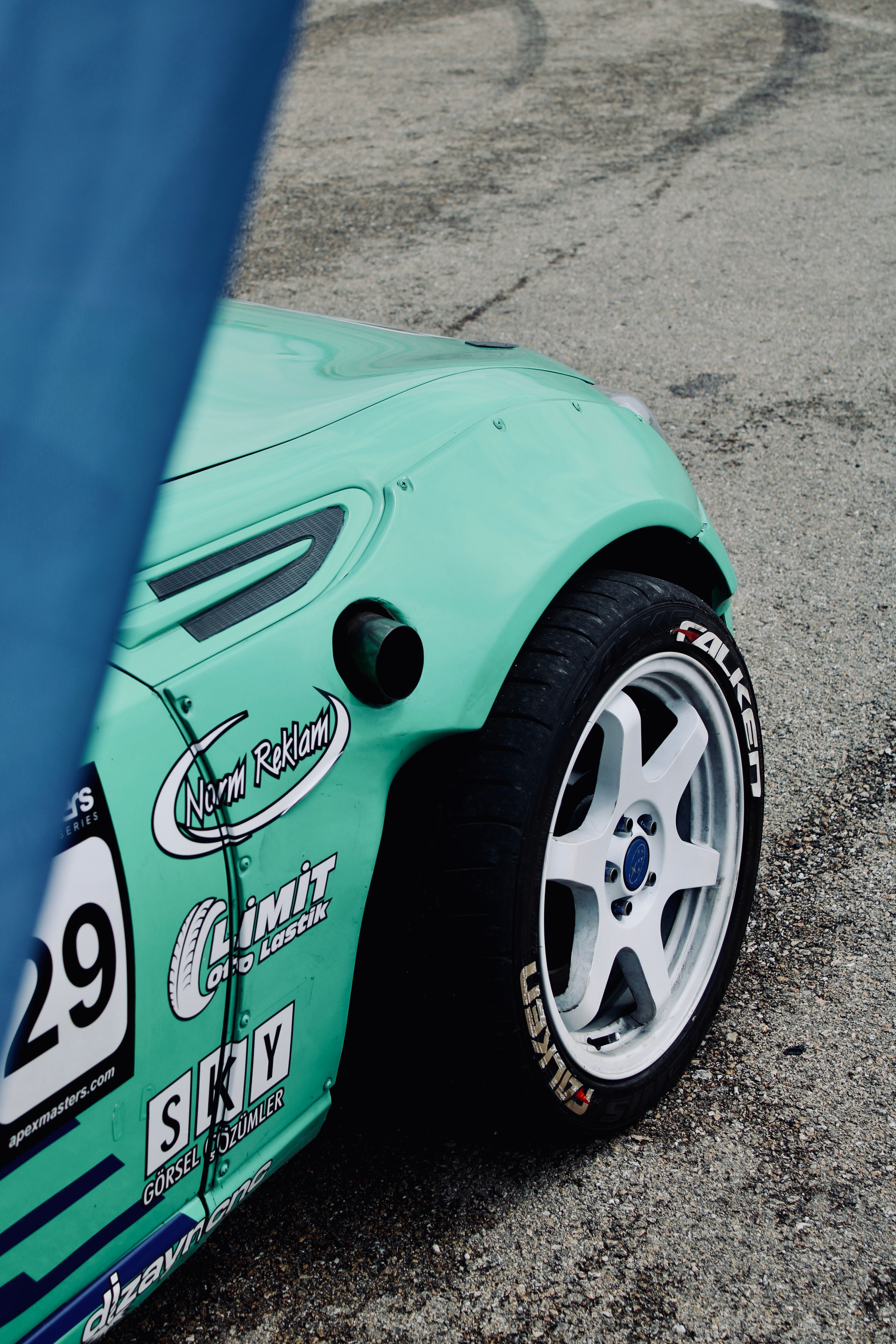 A vibrant green racing car's wheel close-up on a track in Turkey.