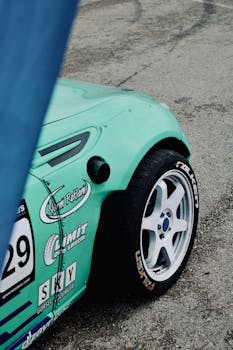 A vibrant green racing car's wheel close-up on a track in Turkey.