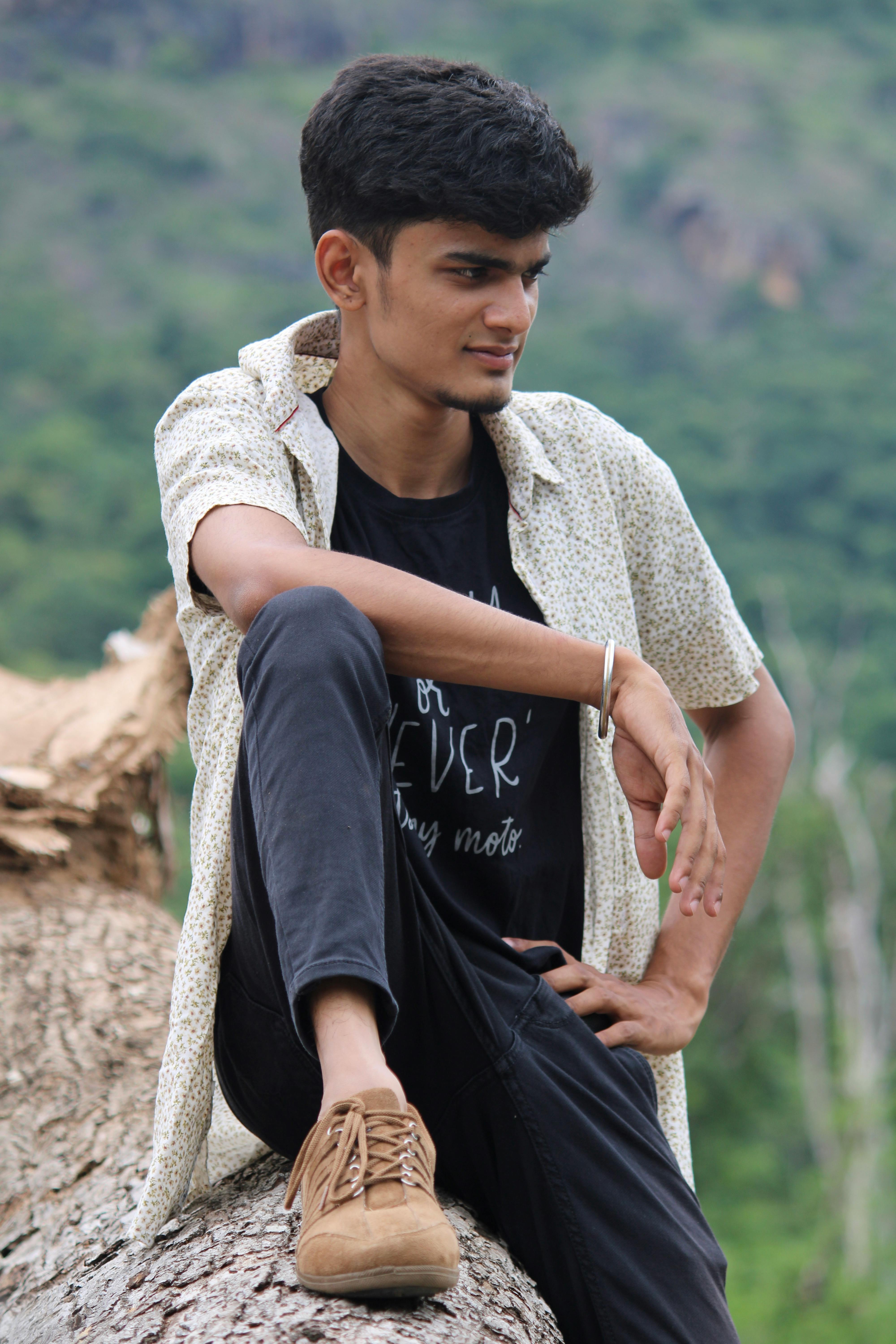 young man sitting on a tree log