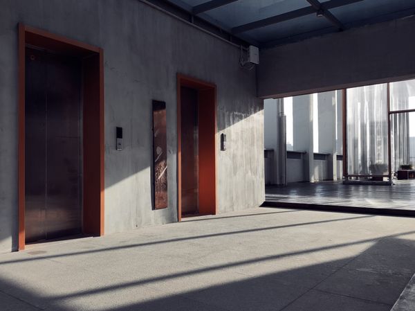 Concrete lobby with oxidised steel doors — photo by yx b on Pexels