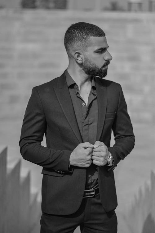 Grayscale Photo of a Man in a Suit Jacket Looking Away