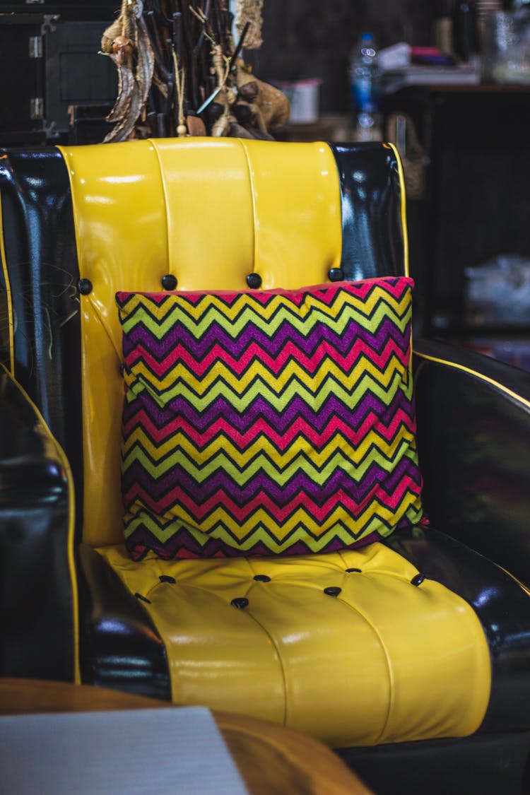 A Leather Chair With A Colorful Pillow