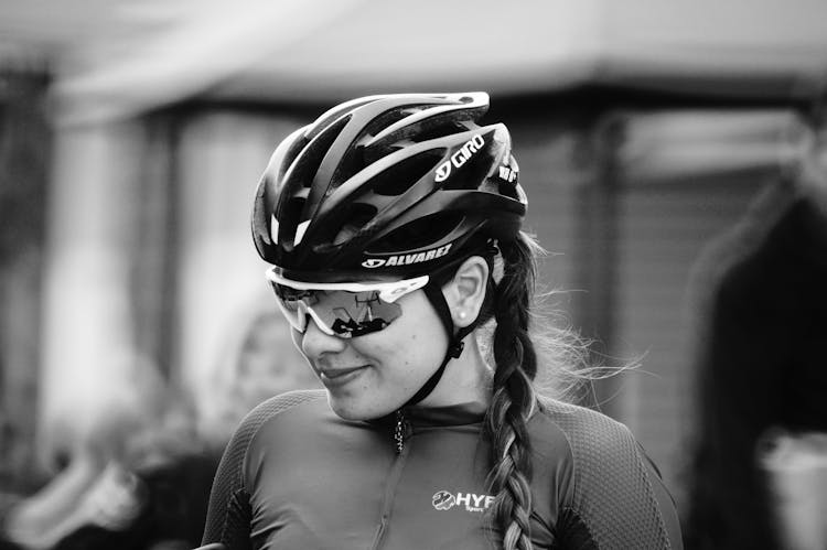 A Grayscale Of A Cyclist Wearing A Helmet