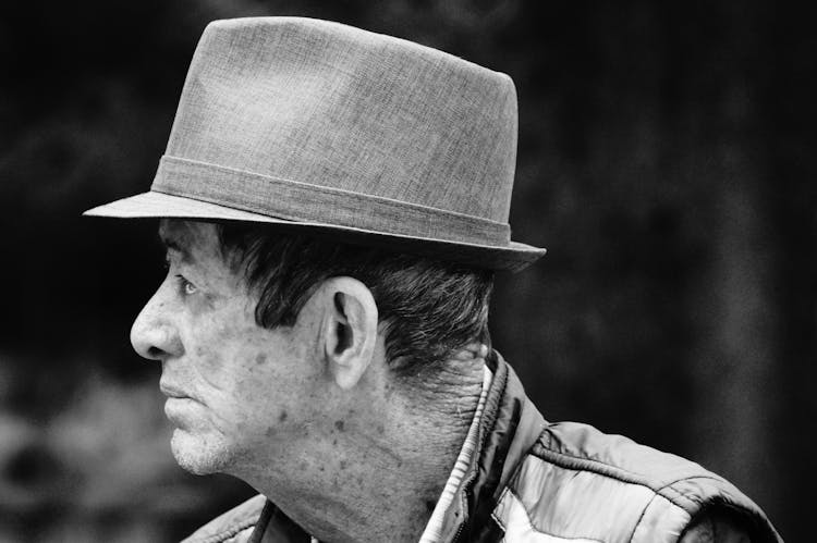 A Grayscale Of An Elderly Man Wearing A Hat