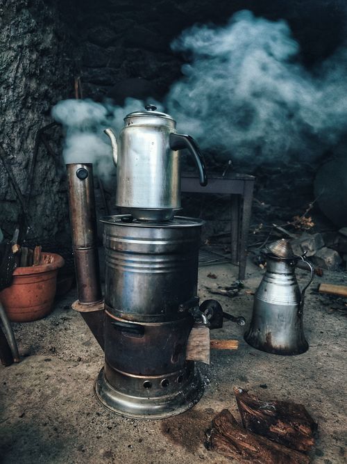 Free Steam rises from a vintage coffee percolator brewing in a rustic setting. Captures the essence of traditional coffee making. Stock Photo