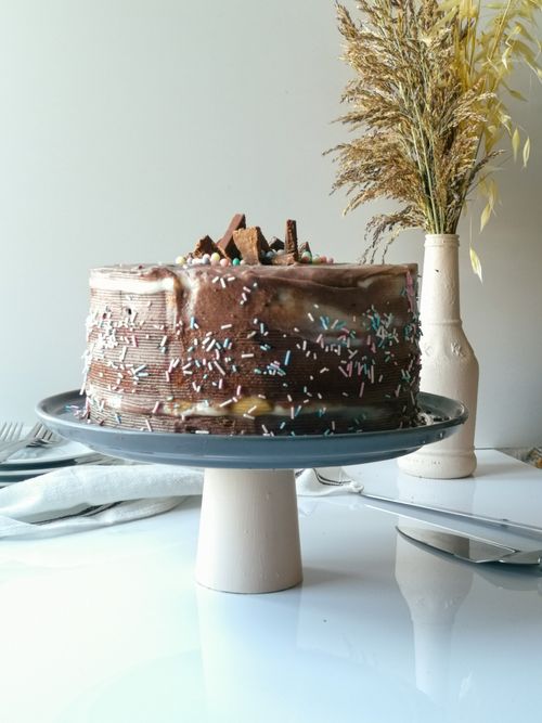 Free Close-up of a chocolate cake with sprinkles on a stand, perfect for dessert inspiration. Stock Photo