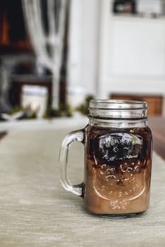 清爽的冰咖啡装在室内桌子上的泥瓦罐里