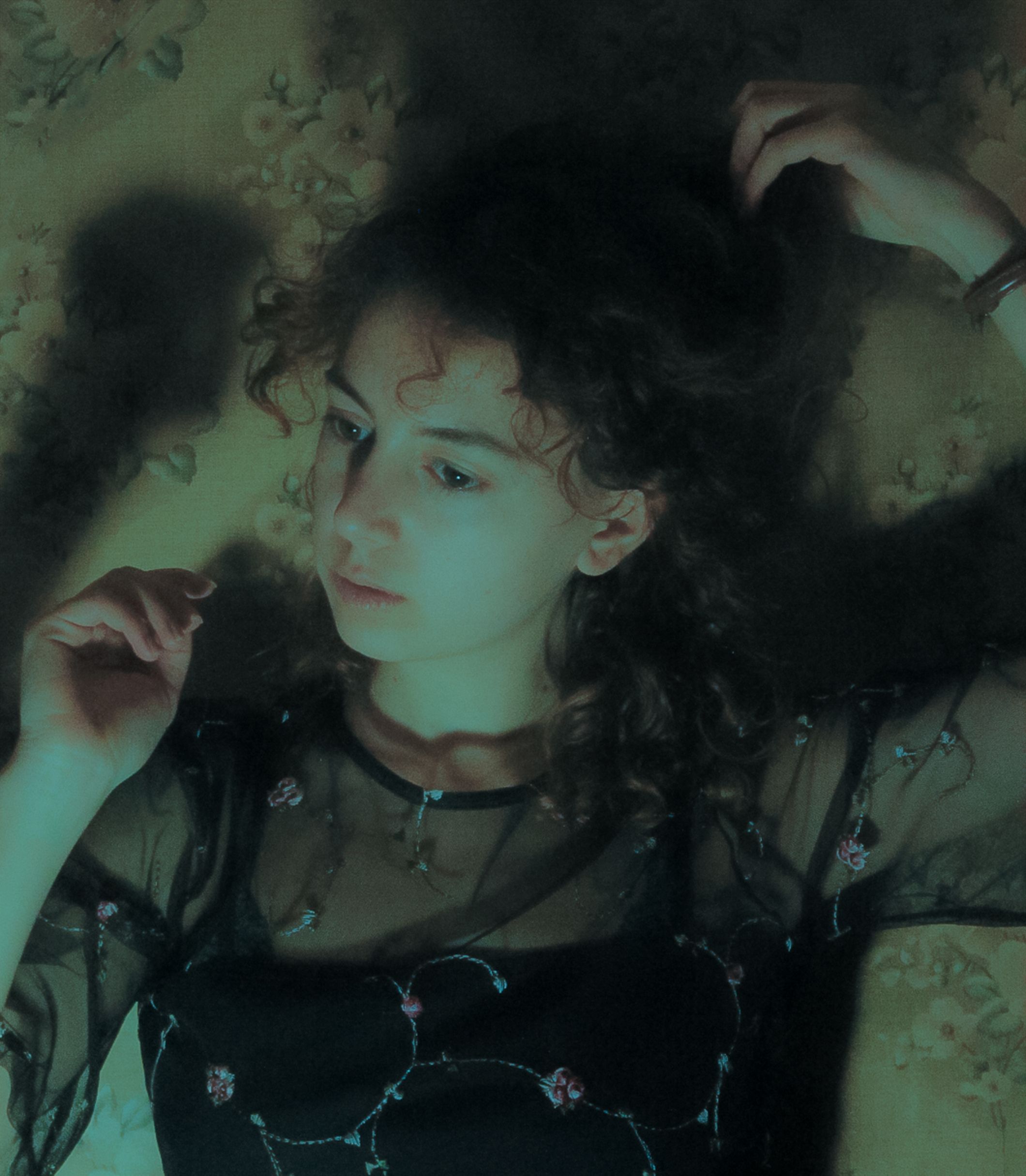 A contemplative woman with curly hair in an elegant tulle dress, fashion portrait.