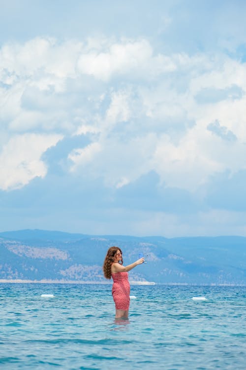 Woman Standing on Shallow Water and Taking Selfie