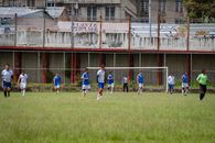 Amateur soccer players compete on an urban field in Venezuela, showcasing teamwork and athleticism.