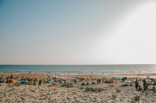 Free A lively beach scene with people enjoying a sunny day by the sea. Stock Photo
