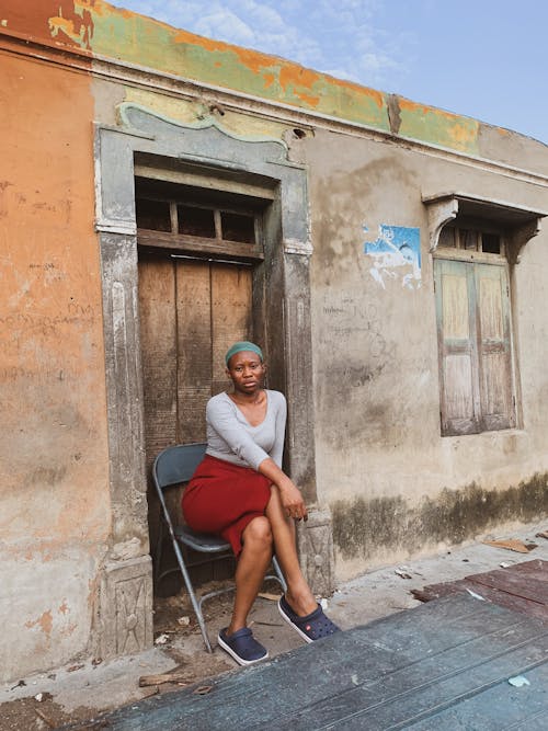 Woman Sitting in front of her House 