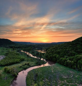 Breathtaking aerial view of a river winding through lush greenery during sunset in Altura, MN.