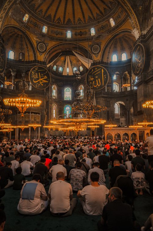 Free Large group of people praying inside a historically significant mosque with elaborate architecture. Stock Photo