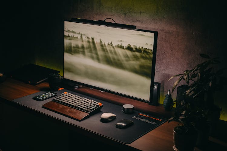 A Computer Setup On A Wooden Desk